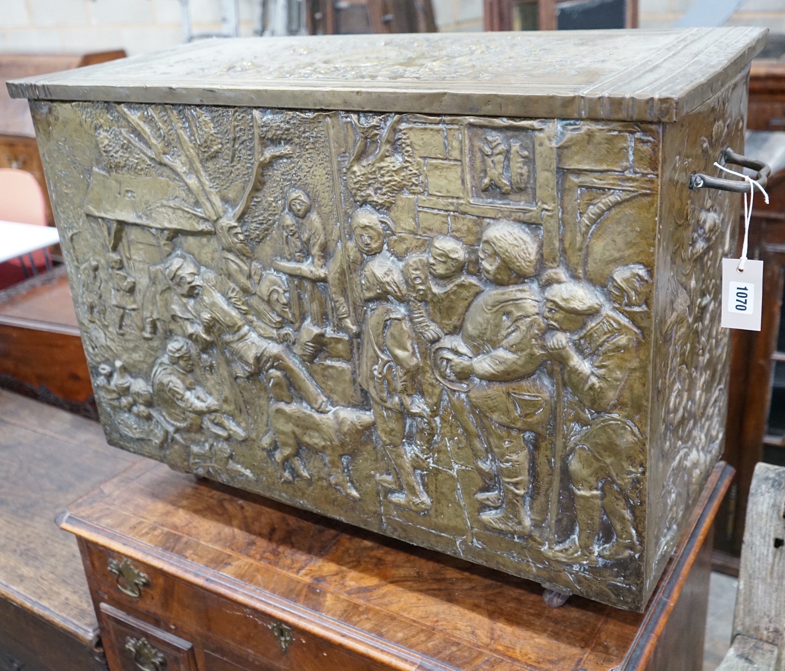 A Dutch style brass repousse log box, width 79cms, depth 35cms, height 57cms.